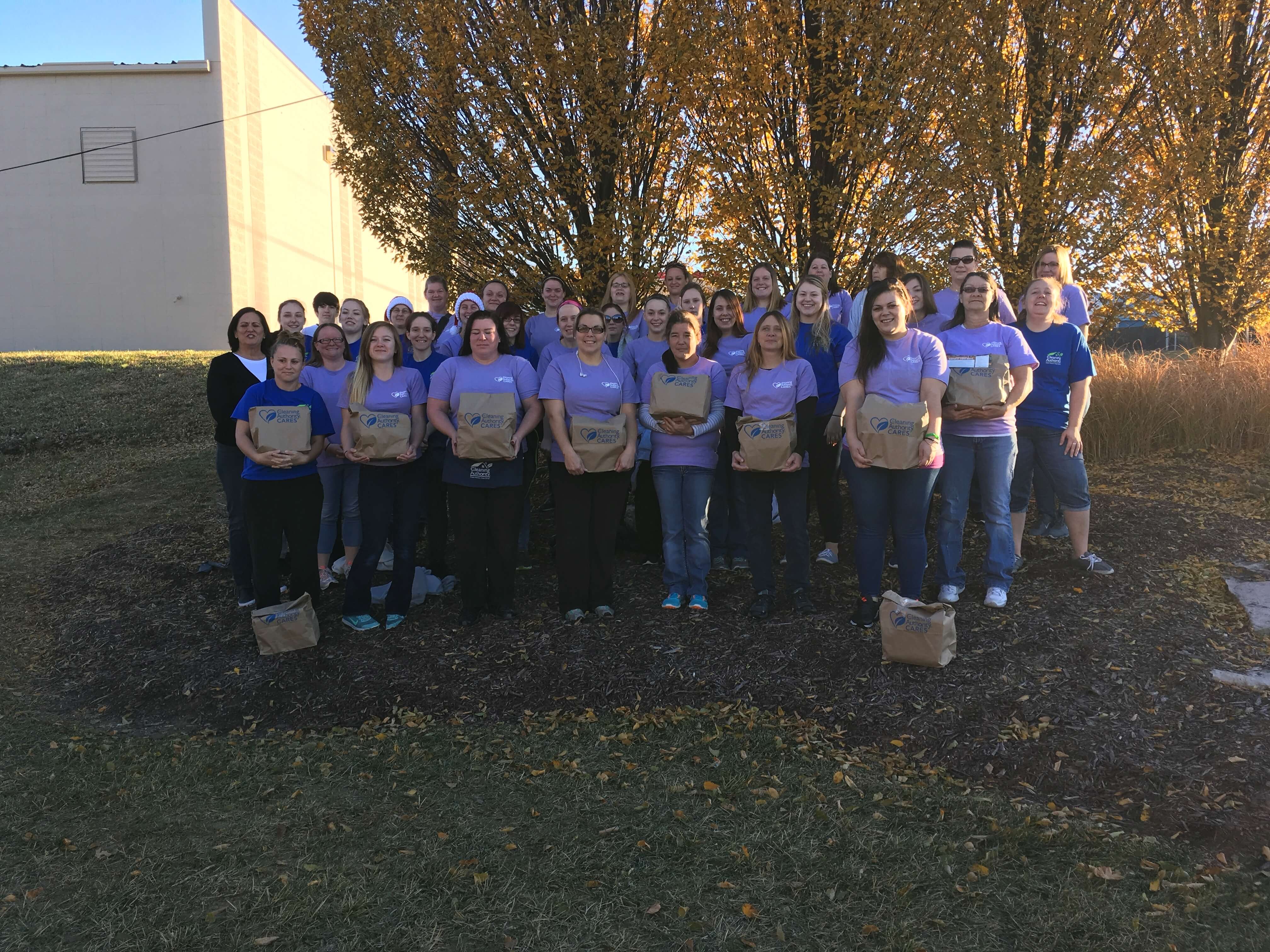 The TCA St. Charles team poses outside with donations collected for a local charity.