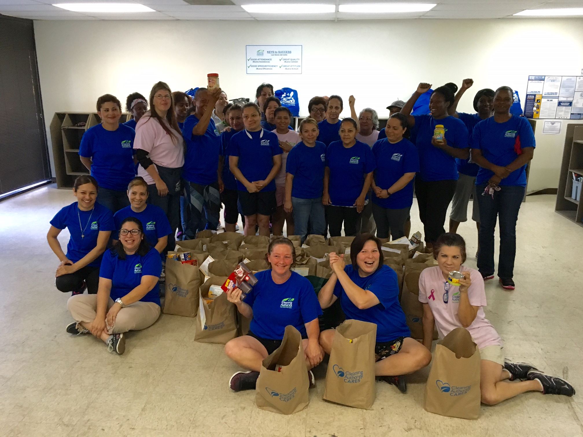 The TCA Plano/Frisco team stands in their office with donations collected for a local charity.